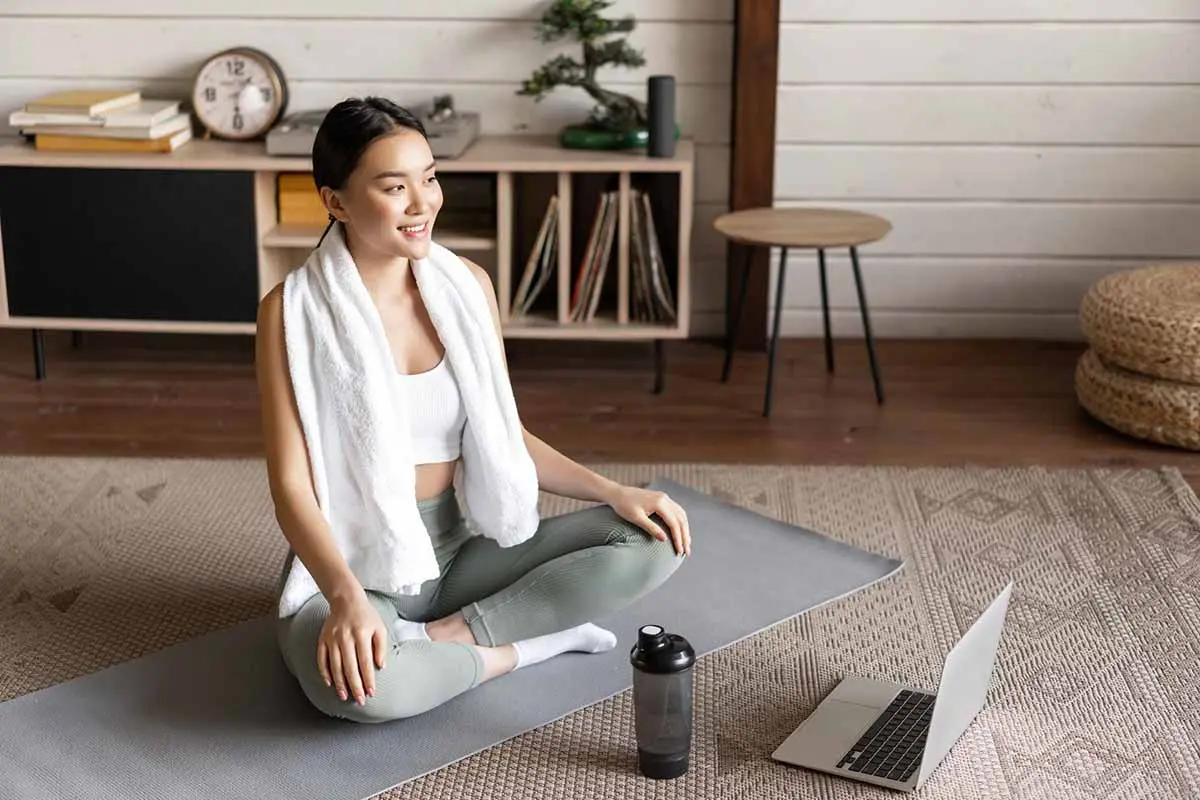 A girl in yoga attire sitting on a mat, creating a calming and organized space for relaxation.