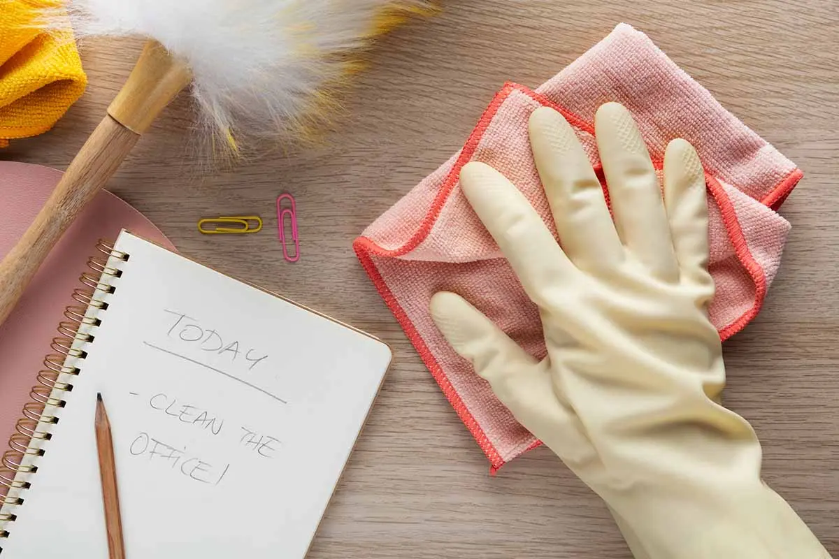Checklist with cleaning supplies on a table.
