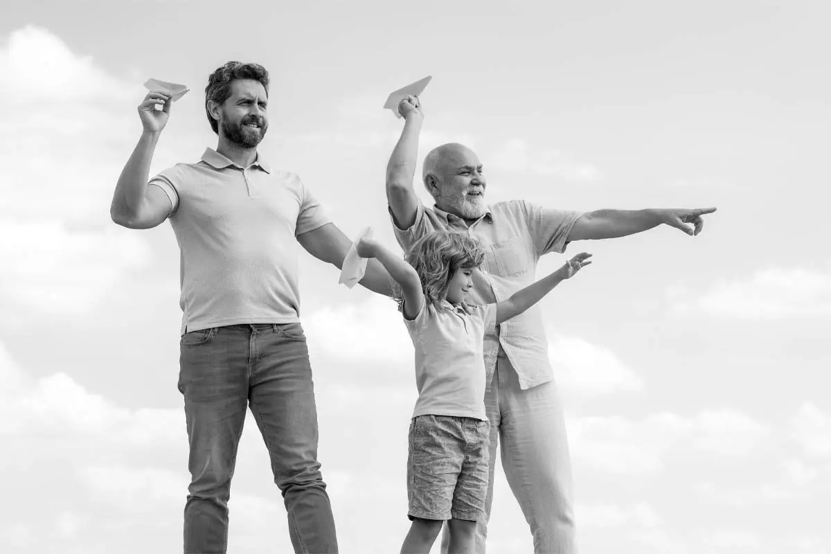 Three generations bonding with paper planes, symbolizing dreams and growth.