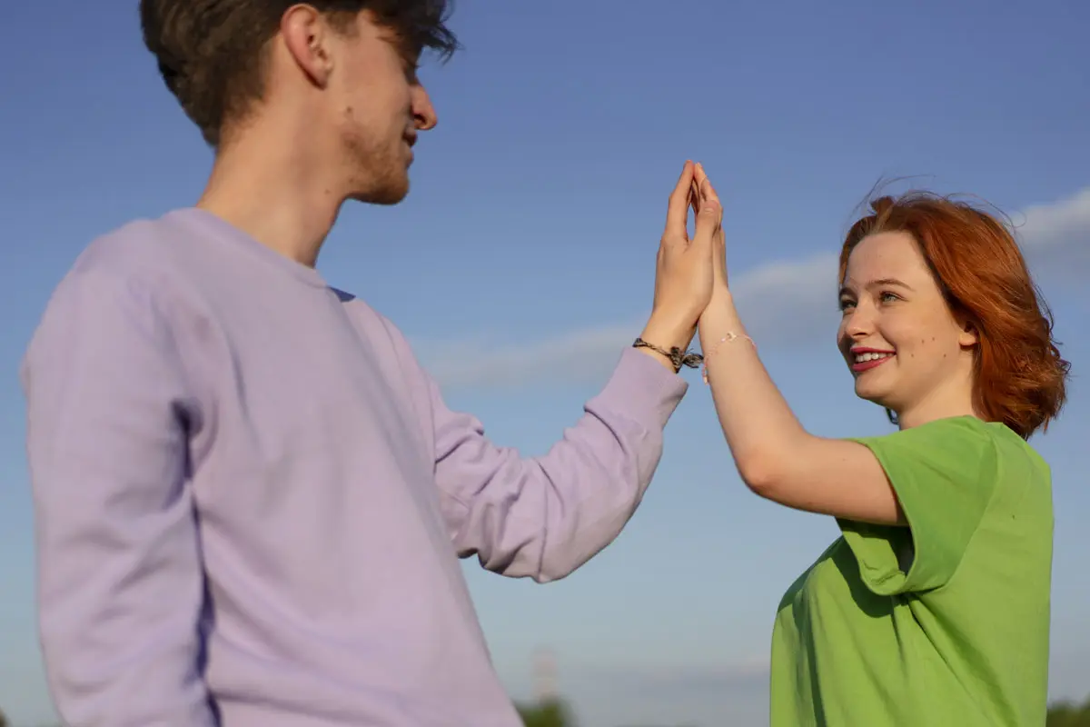 Two people high-fiving, symbolizing teamwork, balance, and support.