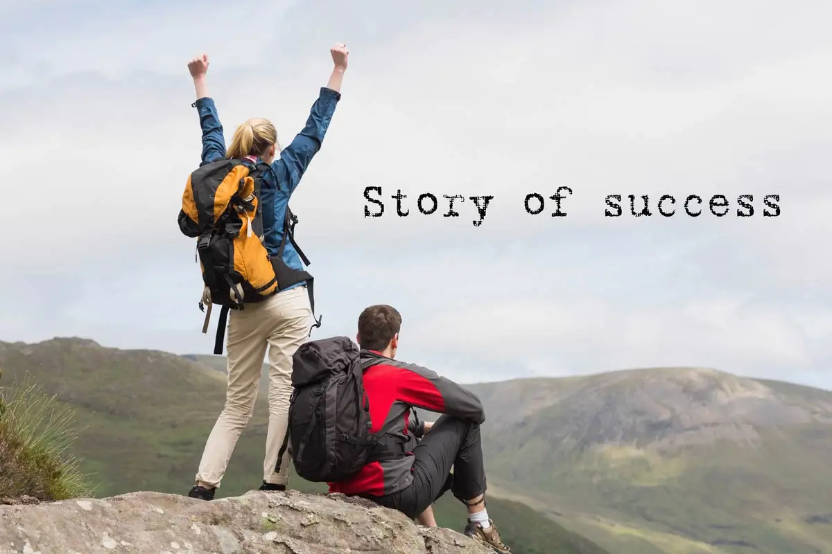 Hikers celebrating success on a mountain peak with scenic views.