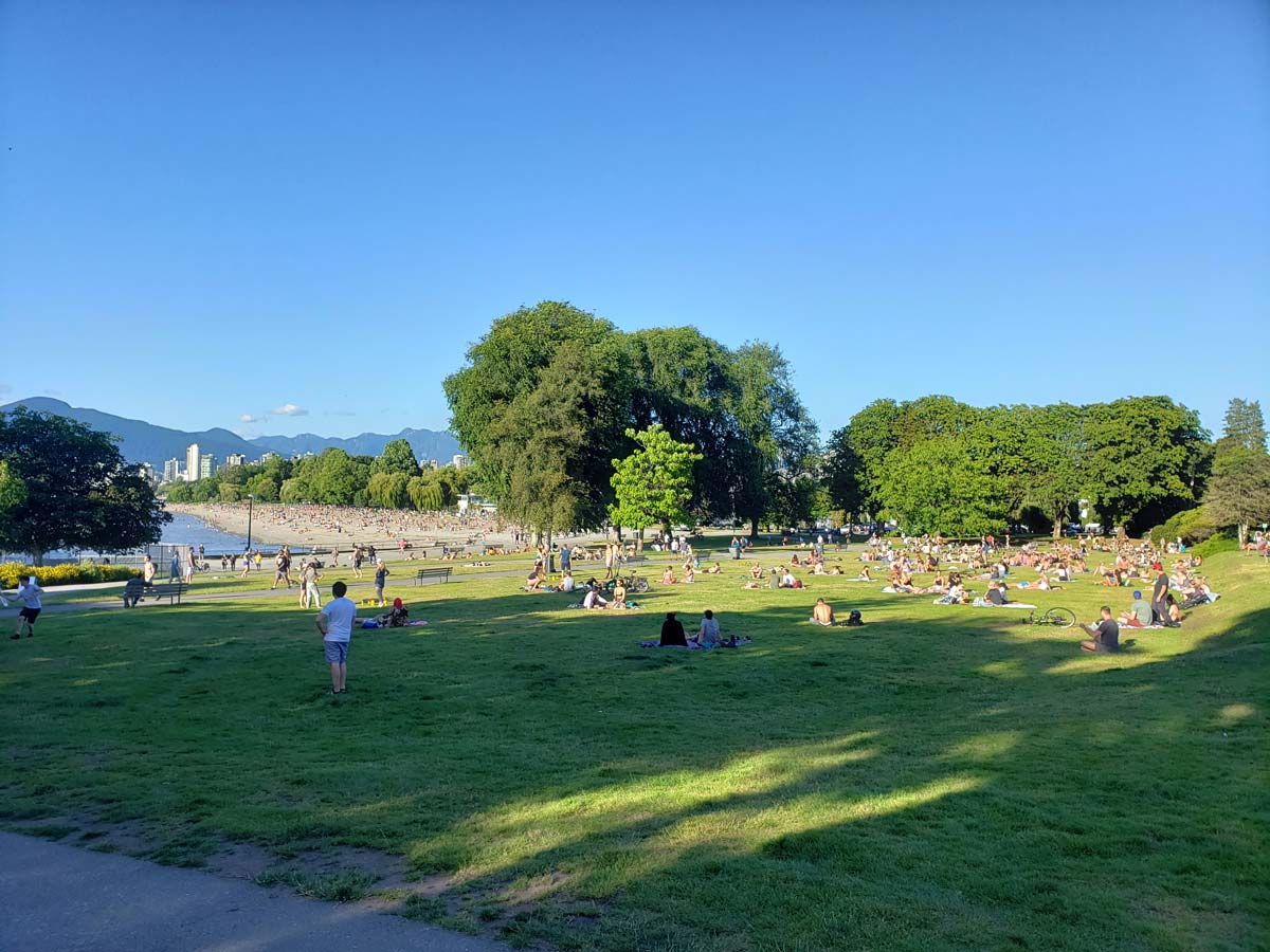 Kitsilano Beach park with people relaxing on a sunny afternoon.
