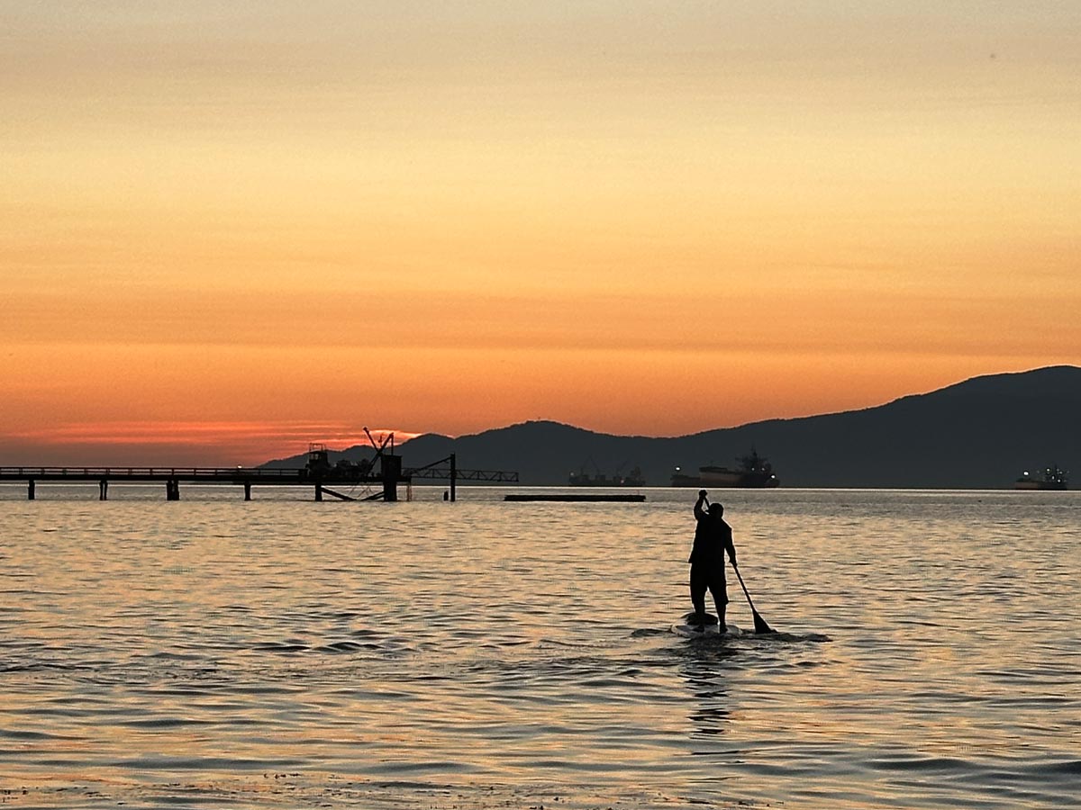 Paddleboarding at sunset near Kitsilano Beach in Vancouver.