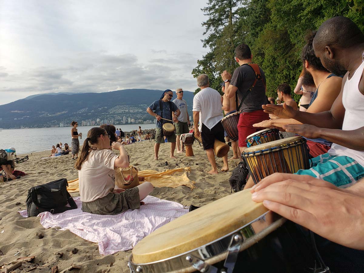 Drummers and beachgoers enjoying a gathering at Third Beach.