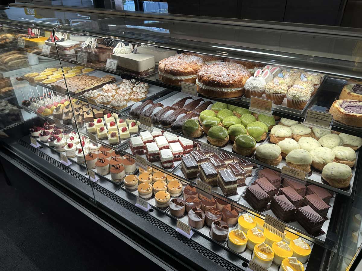 Pastry display filled with colorful cakes and desserts.