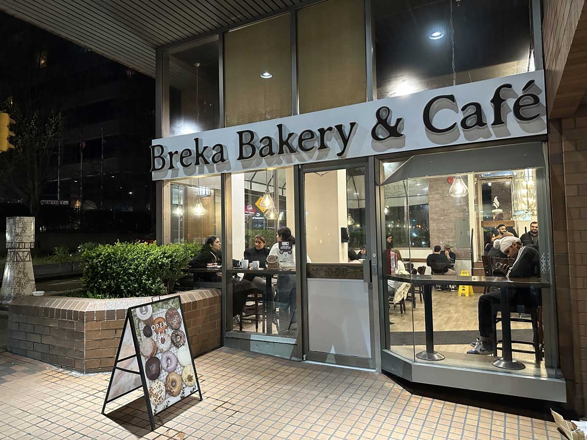 Cozy nighttime view of Breka with customers inside.