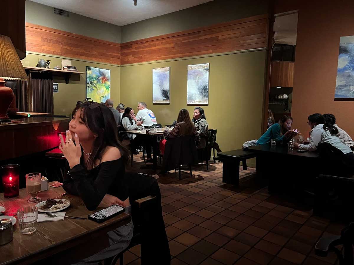 Cozy indoor seating at Cheesecake etc. with guests enjoying dessert.