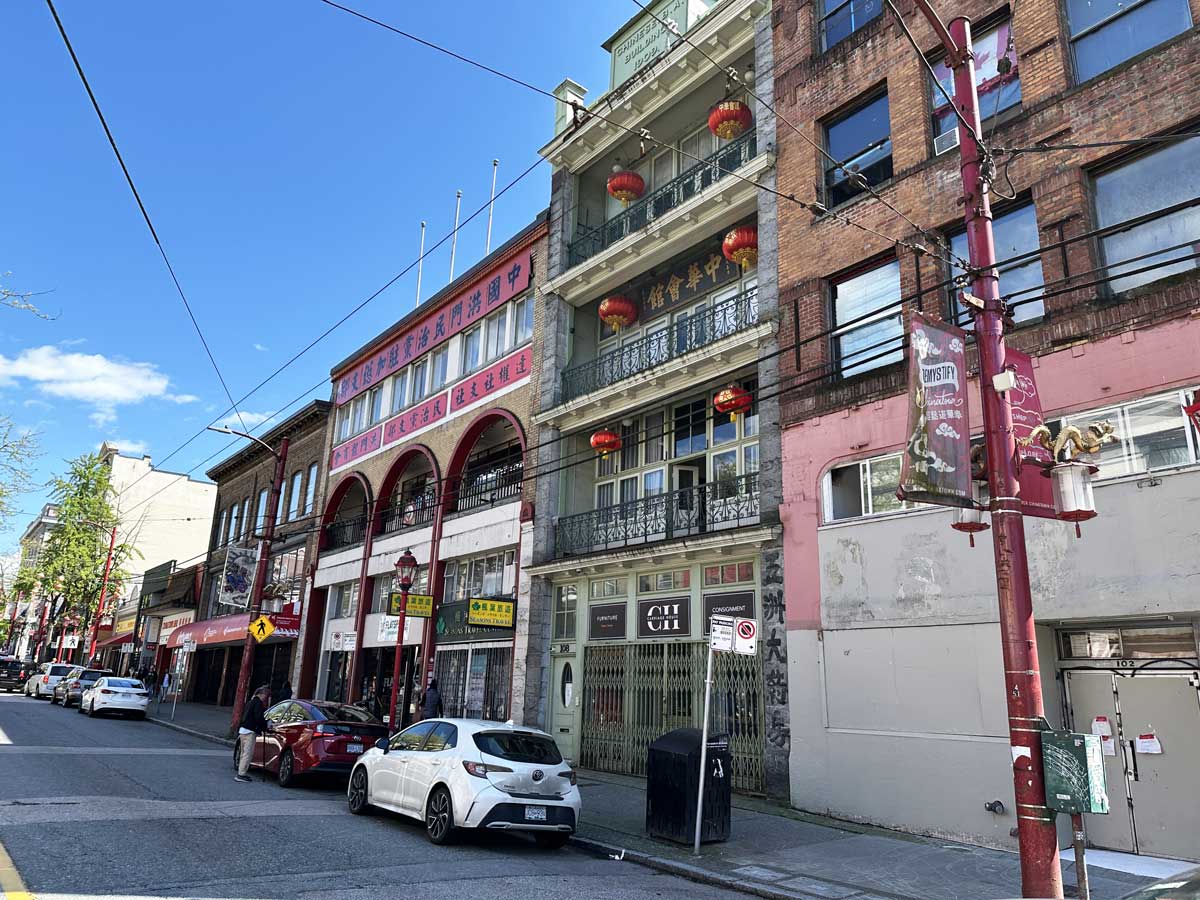 Chinese buildings with red lanterns and signs along Pender Street.