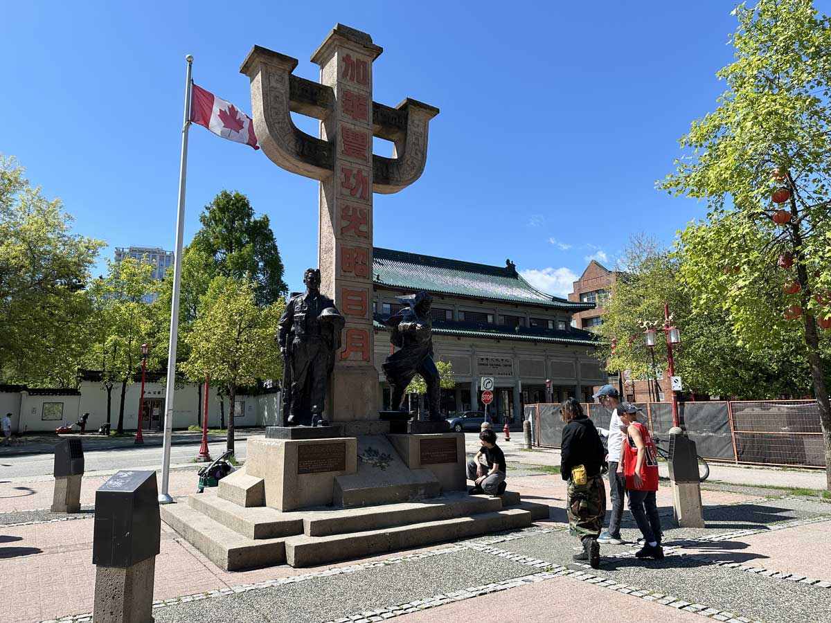 Chinatown Memorial Monument with Canadian flag and visitors.