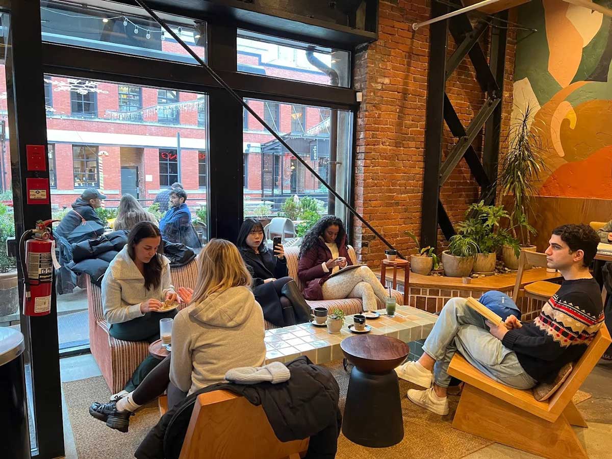 People enjoying coffee and reading inside Analog Coffee Yaletown.