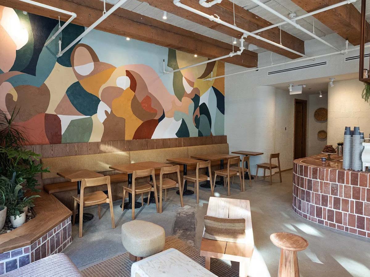 Empty seating area at Analog Coffee with colorful mural wall.