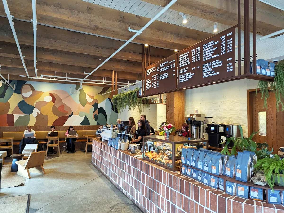 Wide view of Analog Coffee Yaletown with counter and menu board.