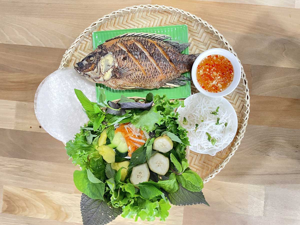 Crispy whole fish with fresh herbs, rice paper, and vermicelli.