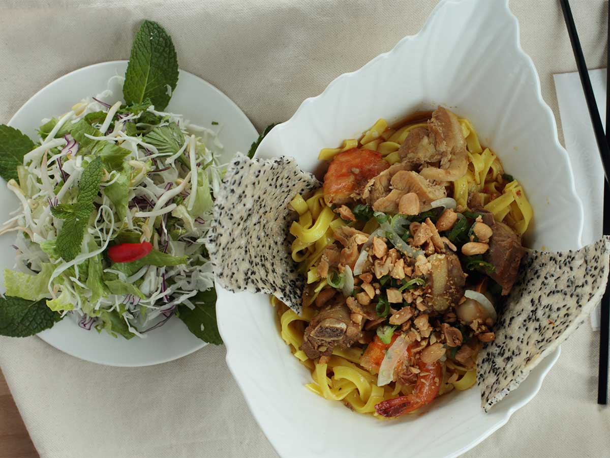 Mi Quang noodles with shrimp, pork, peanuts, and fresh herbs.