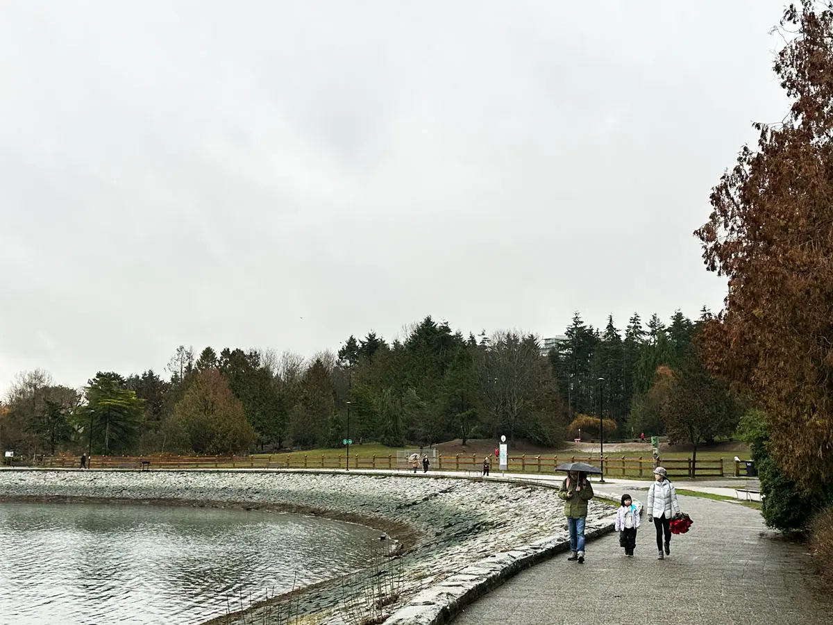 Couple walking along seawall in False Creek wit their kid.