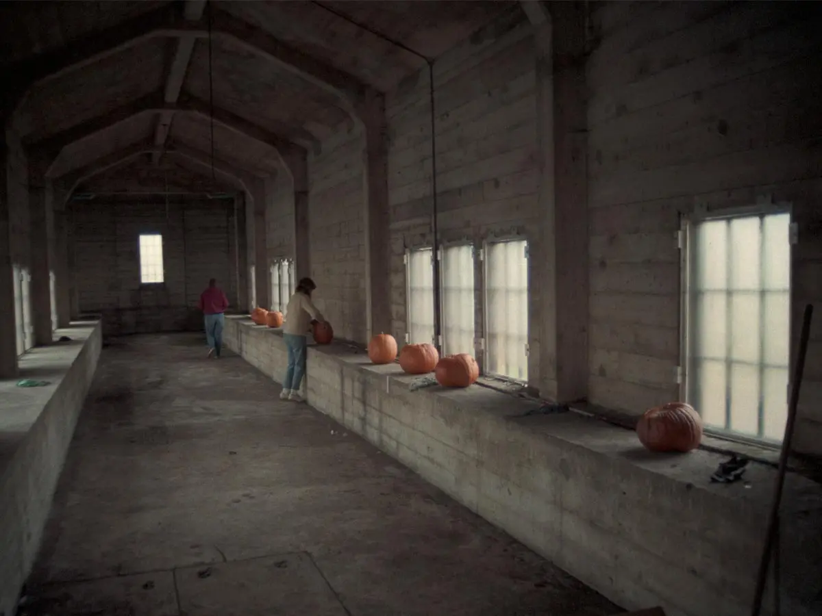 Interior of a Burrard Bridge gallery (1986) with concrete walls, small windows, and pumpkins on a ledge, suggesting Halloween.