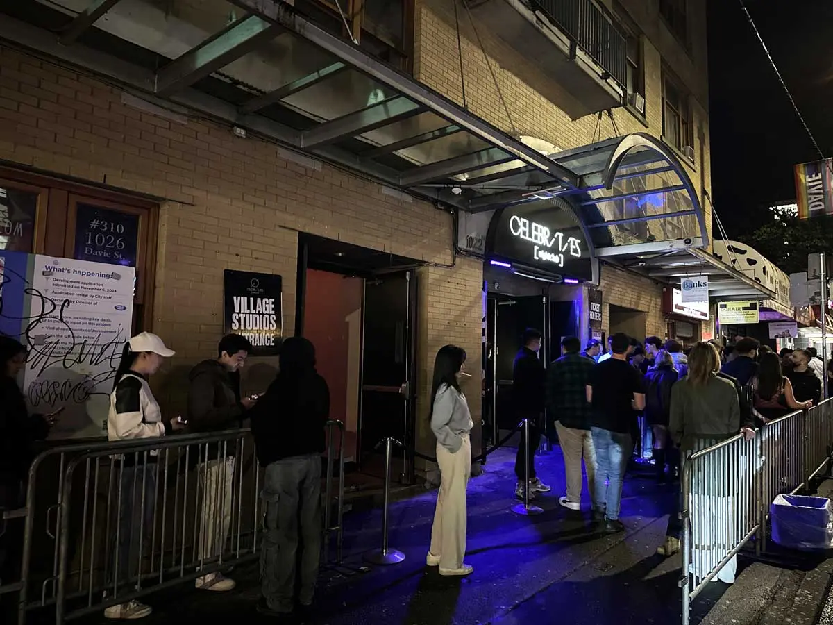 People lining up outside Celebrities Nightclub on Davie Street at night.