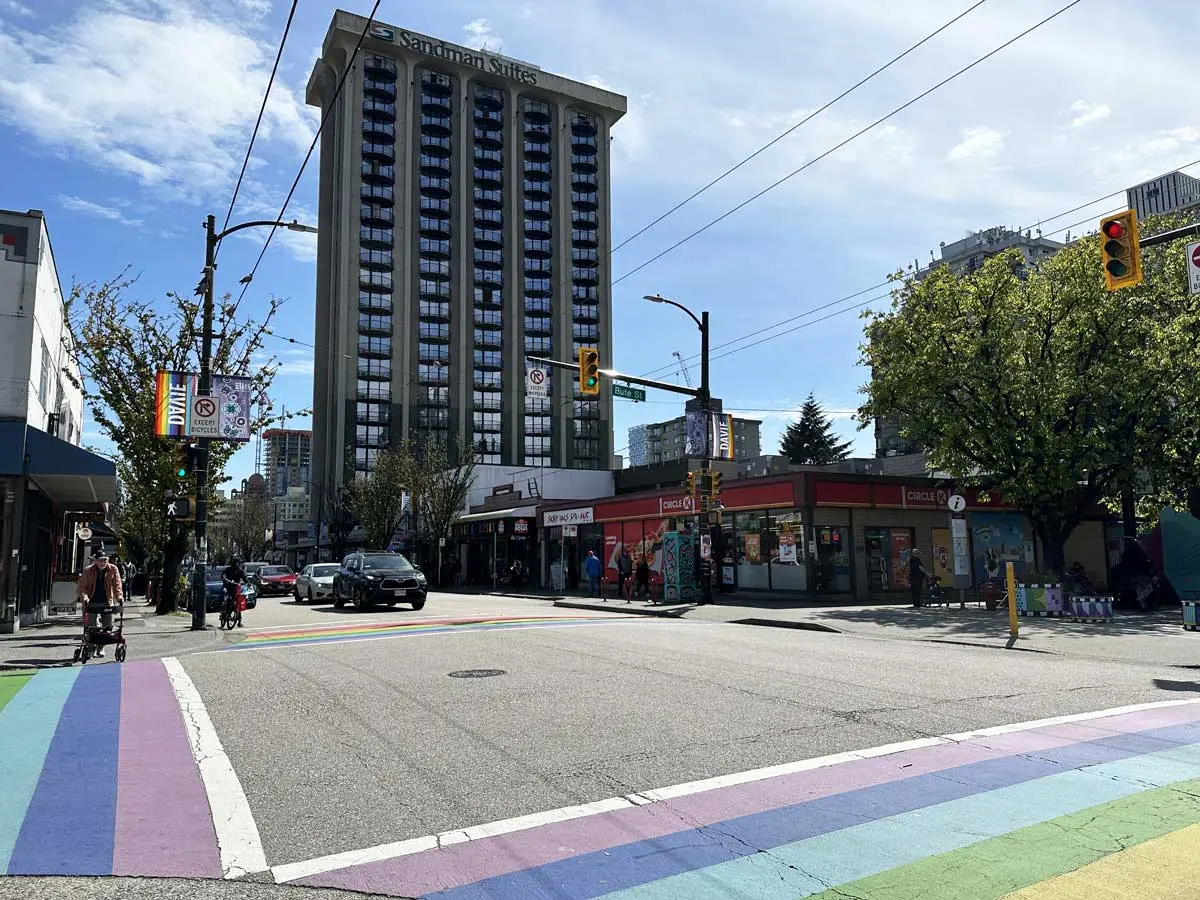 Rainbow crosswalk at Davie and Bute Street with Sandman Suites in the background on a sunny day.