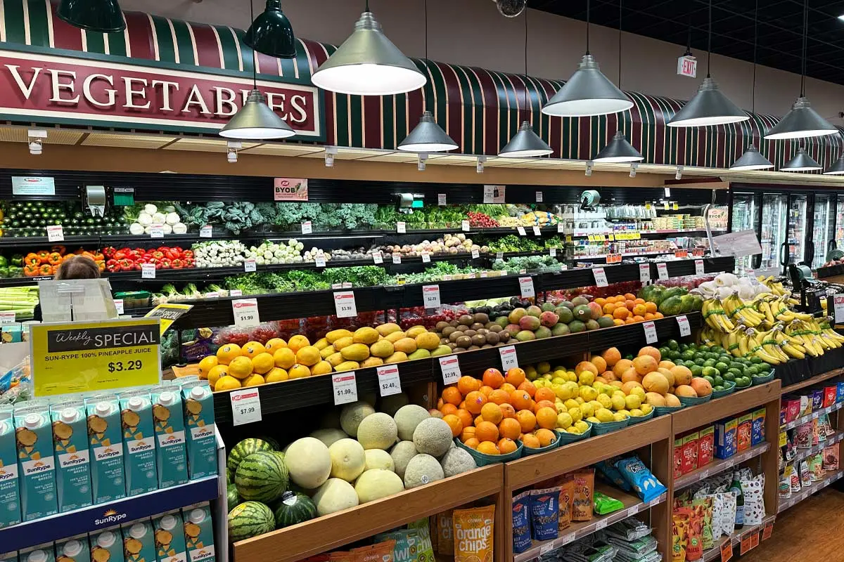 Colorful display of fresh fruits and vegetables in a well-lit Vancouver grocery store.