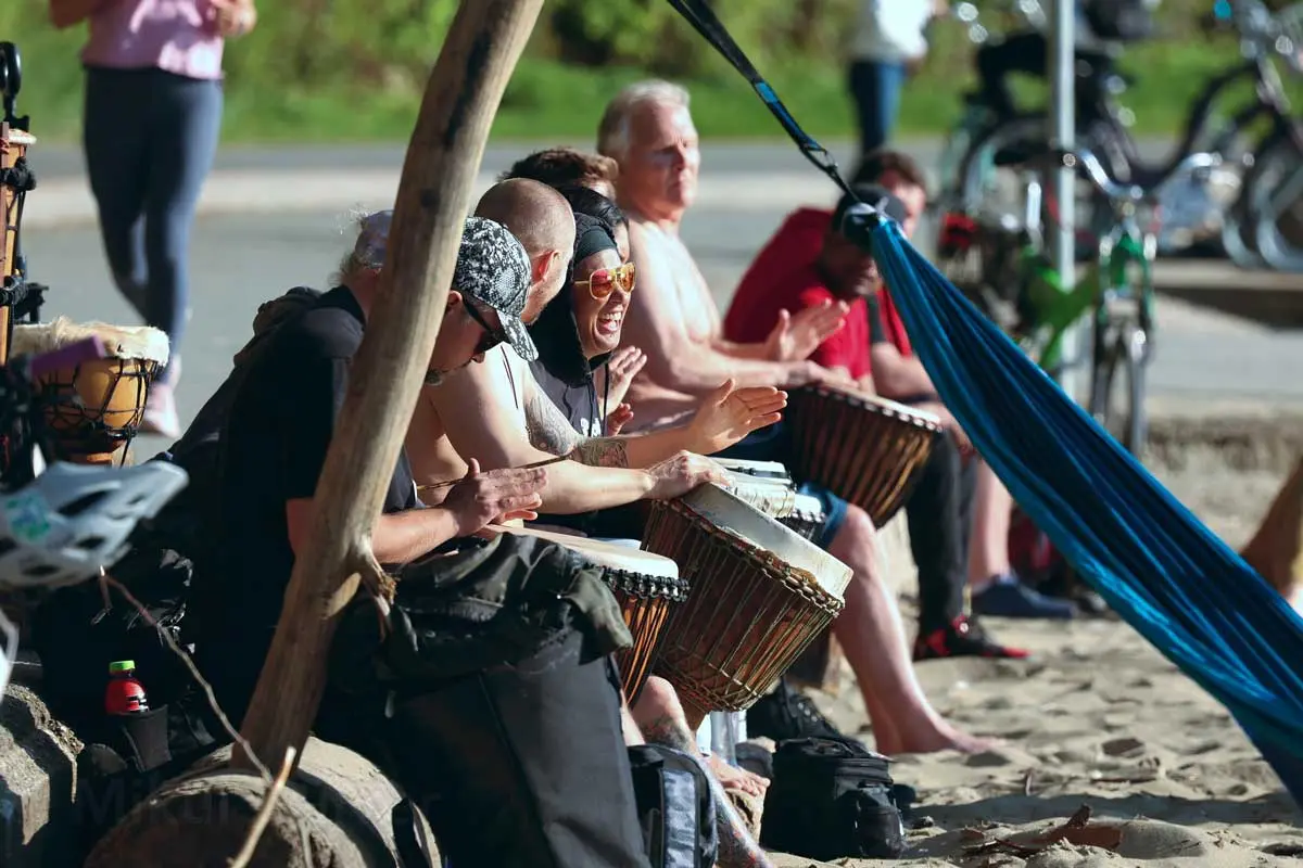 People playing drums and enjoying the beach at Third Beach, Vancouver.