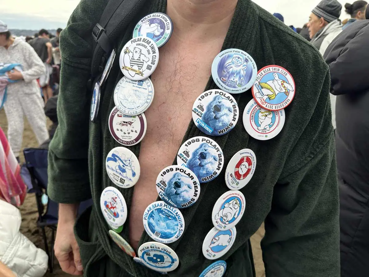 Swimmer proudly wearing Polar Bear Swim badges from past years in Vancouver.