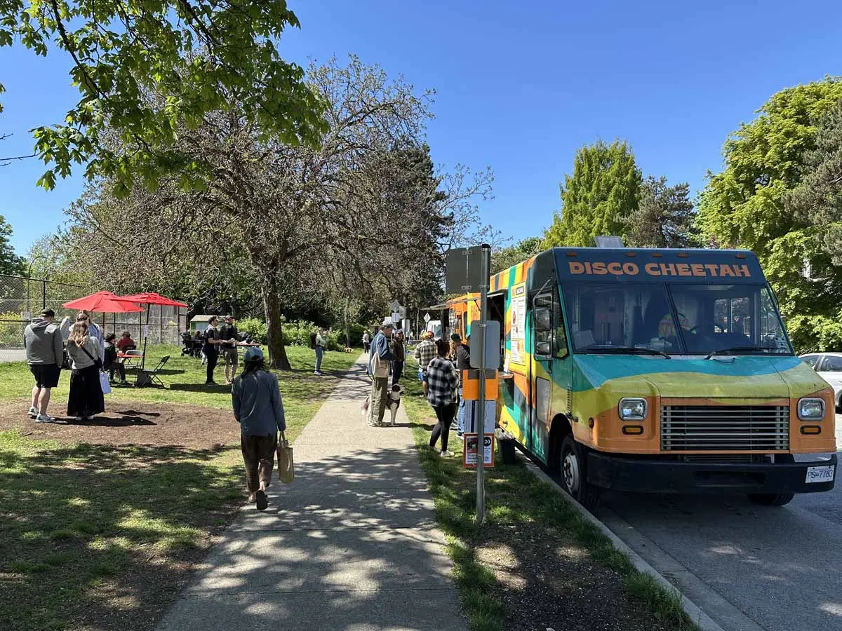 People walking by the Disco Cheetah food truck near Mount Pleasant Farmers Market.
