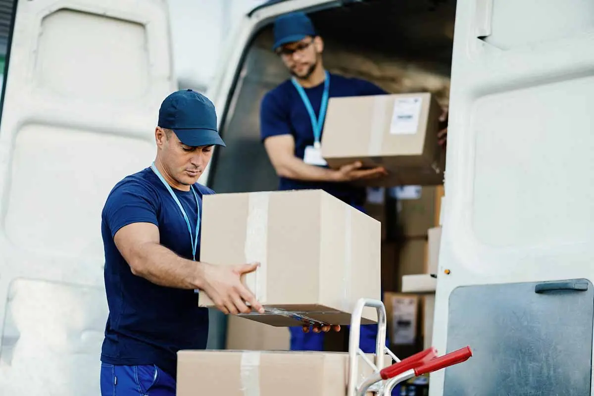 Movers unloading boxes from a van during a relocation.