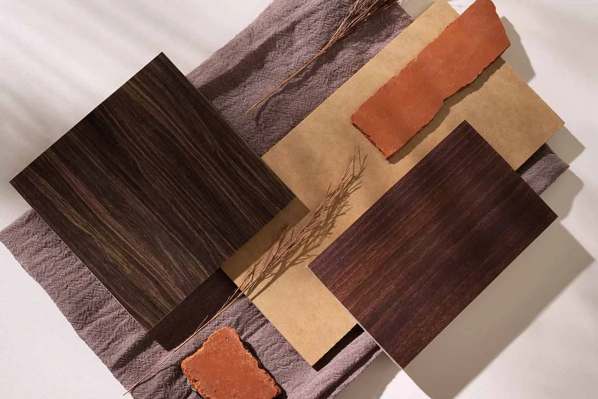 Dark wood flooring samples are displayed on fabric with terracotta accents.
